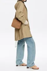 Bolso tote pequeño marca Bimba y Lola, modelo Chihuahua, color marrón. Confeccionado en nylon con estructura blanda, doble asa de mano y asa de tejido, piezas de piel, cierre con botón de presión, logo grabado, acabados metálicos, bolsillo interior e interior con placa metálica logotipada.