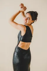 Vestido largo de fiesta negro brillante, de un solo hombro, con abertura lateral en la falda y corte ajustado al cuerpo.