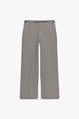 Pantalón de tiro alto con estampado a cuadros en tonos beige y marrón, con bolsillos delanteros y falsos bolsillos traseros. Incluye cinturón marrón con hebilla metálica.