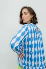 Campera corta de nylon impermeable con estampado de rayas onduladas azules y blancas con medusas rosadas.