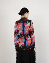 Camisa blanca de corte amplio con cuello clásico y botones negros.