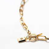 Collar de cadena dorada con dije rectangular y estrella de cristal, acabado en oro 18k.