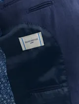 Saco azul de corte clásico con solapas de muesca, cierre de dos botones, bolsillo en el pecho y bolsillos laterales con solapa.