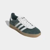 Championes Adidas Gazelle Indoor de color verde oscuro con las tres tiras laterales blancas y suela de goma color caramelo. Presentan un exterior de cuero con detalles sintéticos, cordones blancos y el nombre del modelo grabado en dorado.
