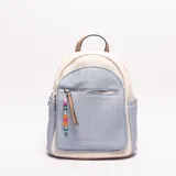 Mochila pequeña de mujer con diseño tricolor: paneles laterales y superior en tejido de paja color crudo, panel frontal y bolsillos laterales en material texturizado color celeste pálido, y detalles en cuero sintético color camel. Cuenta con un bolsillo frontal con cierre y un colgante decorativo de cuentas de colores.