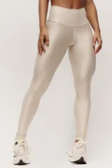 Calza larga color beige de cintura alta, confeccionada en poliamida y elastano.