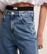 Pantalón de jean celeste de corte wide leg, cintura alta con elástico negro y pespuntes contrastantes.