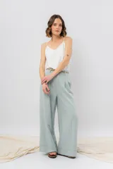 Pantalón negro de corte ancho y fluido, tiro medio con presillas para cinturón, bolsillos laterales funcionales y pinzas delanteras.