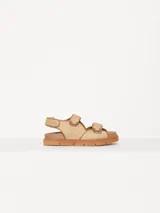Sandalias bajas color beige con tiras de rafia y ajuste con velcro.