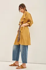 Saco color mostaza confeccionado en lino, de corte amplio y mangas largas. Incluye lazo estampado animal print.