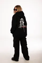 Buzo hoodie negro con capucha y cordones ajustables. Estampado en la espalda con la imagen de un rostro y la frase "Beyond Limits" en blanco y rojo.