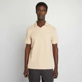 Remera de hombre color beige claro, de punto piqué, con cuello polo y mangas cortas.