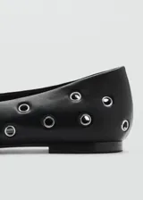 Zapato tipo ballerina color blanco con perforaciones circulares y punta redonda.