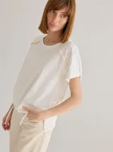 Remera negra de algodón con mangas cortas con detalle de calado y bordado en los hombros y mangas. Corte recto con cintura ajustable con cordón.