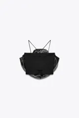 Top negro de organza con cuello halter, tirantes finos y detalle de maxi flor con volumen.