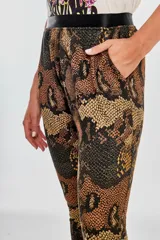 Pantalón babucha con estampado de piel de serpiente en tonos marrones y negros, con cintura alta elástica en color negro.