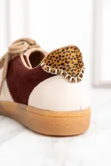 Zapatillas deportivas marrones con detalles en color borgoña y blanco, con cordones y suela de goma.