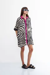 Vestido camisero con estampado de cebra, cuello camisero con vivos fucsia y corte holgado.