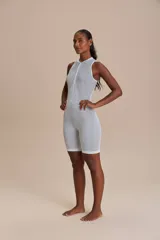 Enterito corto color salmón, de tejido de punto sin costuras, con cierre frontal y espalda descubierta.