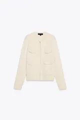 Chaqueta color crema de cuello redondo y manga larga, con bolsillos de parche con solapa en el frente y cierre frontal con corchete oculto.