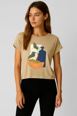 Remera de viscosa color gris claro con estampado abstracto en el frente, de manga corta, corte al cuerpo y cuello redondo.