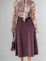 Falda midi de micro pana color morado oscuro, de corte recto y cintura elastizada. Incluye un cinturón desmontable de cuero marrón.