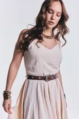 Vestido midi color beige de breteles finos, corte asimétrico y falda con volados.