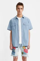 Camisa de mezclilla de corte relajado, con botones frontales y dos bolsillos en el pecho.