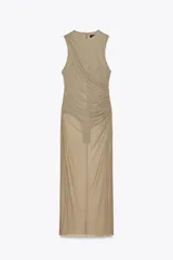 Vestido midi color beige de tul, con cuello redondo y sisa americana. Presenta frunces en el lateral y forro interior tipo body con botones a presión.