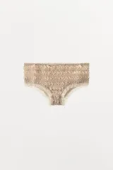 Mini shorts color beige confeccionados en tejido con estructura, tiro alto, cintura elástica y detalle de volantes a tono en los bordes.