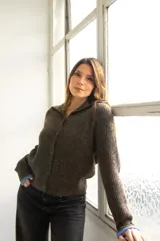 Cárdigan marrón de tejido con relieve, cuello camisero, botones al frente y detalles de color celeste en cuello y puños.