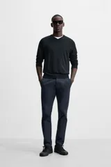 Pantalón chino azul marino, corte skinny fit, confeccionado en tejido de algodón con elasticidad. Cuenta con bolsillos frontales y traseros de vivo. Cierre frontal con cremallera y botón.