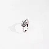 Anillo de plata 925 con circonias engarzadas. El anillo tiene un diseño delicado y elegante, con una circonia central redonda rodeada de pequeñas circonias brillantes.