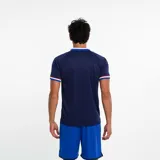 Polo deportivo azul marino con cuello tipo camisa y tres botones. Los bordes de las mangas y el cuello tienen detalles de rayas blancas y rojas. Lleva el escudo del Club Nacional de Football bordado en el pecho.