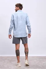 Camisa de lino color crudo, de corte recto, con cuello clásico y mangas largas.