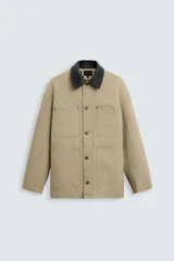 Parka color beige de algodón con cuello solapa combinado en cuero negro, corte recto, cierre frontal con botones y bolsillos de parche.