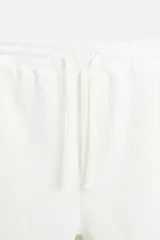 Bermuda negra de corte relaxed fit, con cintura elástica ajustable con cordón, bolsillos frontales y bolsillo trasero de parche.