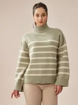 Suéter de tejido de punto color gris melange, con cuello alto y diseño a rayas horizontales en blanco y verde salvia. Presenta un calce holgado y puños y ruedo con terminación acanalada.
