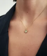 Collar plateado con dije en forma de estrella con piedra verde engarzada.