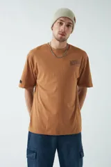 Remera oversize color marrón con arte estampado de sol y luna, diseñada para un look amplio y relajado.