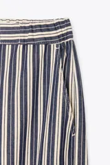 Pantalón de tiro medio con cintura elástica ajustable con cordones, bolsillos delanteros y traseros de parche. Pierna ancha con estampado de rayas verticales azules y blancas.