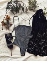 Body de lurex plateado con espalda abierta y tiras ajustables, ideal para ocasiones nocturnas.