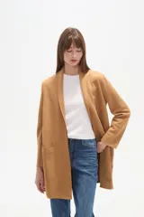 Tapado largo color camel, de manga larga y corte holgado, con solapa tipo chal y bolsillos frontales.