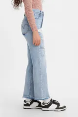 Pantalón de jean celeste claro, de corte recto, tiro alto y largo hasta el tobillo. Presenta roturas grandes en ambas piernas y terminación desflecada.