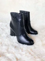 Bota corta negra con textura croco, punta redonda y taco forrado de 8.5 cm.