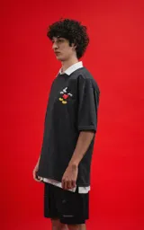 Remera gris oscuro con cuello polo blanco y estampado de Mickey Mouse en el pecho.