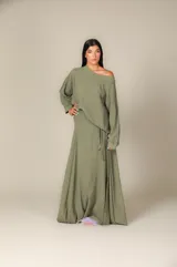 Blusa color crema de gasa con escote asimétrico y manga larga.