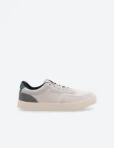 Championes urbanos de caña baja, color blanco hueso, con detalles en gris y azul marino.