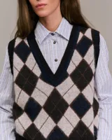 Chaleco de punto con patrón de rombos en tonos beige, verde y gris. Escote en V y ribete acanalado en el bajo. Sin mangas.