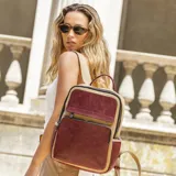 Mochila combinada color verde militar y cuero sintético color mostaza, con doble bolsillo frontal, asa de mano y correas regulables.
